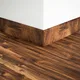 A close-up of a MDF Skirting Aristo Premium PM 00364 D | 8 ft x 2.5 Inch | Compatible for Laminate Wood Floor LF 00247 available at Material Depot in Bangalore