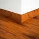 A close-up of a MDF Skirting Aristo Premium PM 00366 D | 8 ft x 2.5 Inch | Compatible for Laminate Wood Floor LF 00252 available at Material Depot in Bangalore