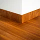 A close-up of a MDF Skirting Heirloom PM 00348 G | 8 ft x 4 Inch | Compatible for Laminate Wood Floor LF 00268 available at Material Depot in Bangalore