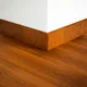 A close-up of a MDF Skirting Aqua Lock PM 00401 E | 8 ft x 3 Inch | Compatible for Laminate Wood Floor LF 00284 available at Material Depot in Bangalore