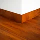 A close-up of a MDF Skirting Aqua Lock PM 00403 G | 8 ft x 4 Inch | Compatible for Laminate Wood Floor LF 00286 available at Material Depot in Bangalore