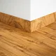 A close-up of a MDF Skirting Aqua Lock PM 00405 E | 8 ft x 3 Inch | Compatible for Laminate Wood Floor LF 00288 available at Material Depot in Bangalore