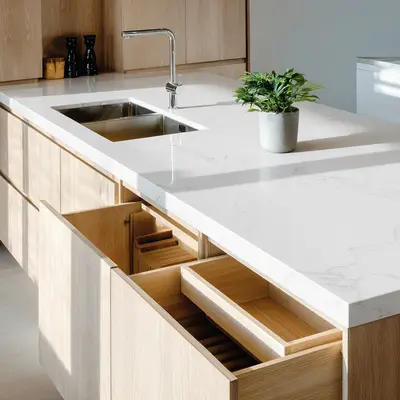Modern kitchen with olive green high gloss laminate, white quartz countertop, and floral tropical backsplash tile