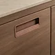 HA 00193 F Ottr Concealed Handle Rose Gold Dual Tone Finish 96mm â close-up of copper handle on walnut cabinet
