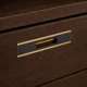 HA 00198 Ottr Concealed Handle Black Pvd Gold Finish 8in â close-up of gold-framed black handle on dark wood drawer