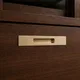 HA 00203 H Ottr Concealed Handle Stainless Steel Chrome Finish 18in â close-up of champagne bronze handle on dark wood drawer