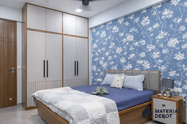 Modern bedroom with blue floral wallpaper, grey laminate wardrobe, and wooden bed