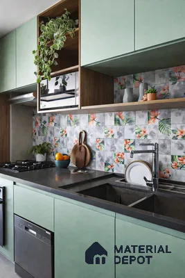 Modern kitchen with pastel green laminate cabinets, floral patterned backsplash tiles, and grey quartz countertop