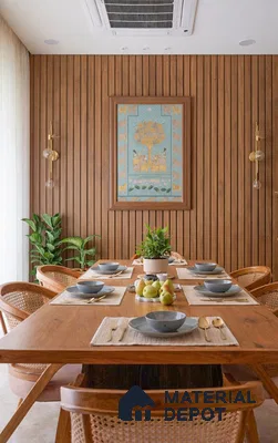 Scandinavian dining room with natural oak wood table, cane chairs, and vertical wood louver wall panels