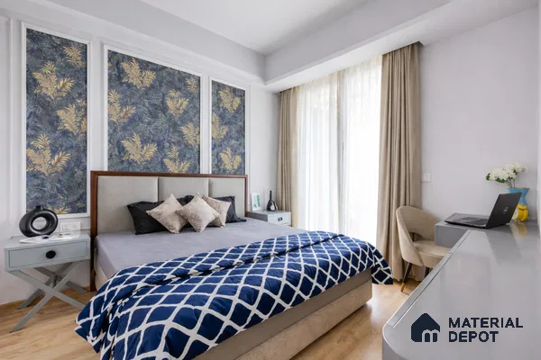 Modern bedroom with blue and gold floral wallpaper, beige upholstered bed, and light wood flooring