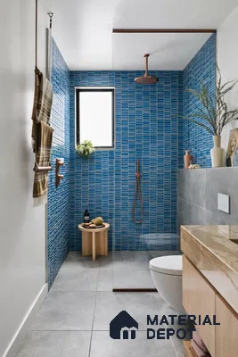 Modern bathroom with blue kitkat subway wall tiles, grey stone floor tiles, and beige marble countertop