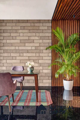 Modern dining room with beige brick wall tile, walnut wood louvers, and black polished floor tile in 3 BHK apartment Hilife Triflora Gunjur Road Bengaluru