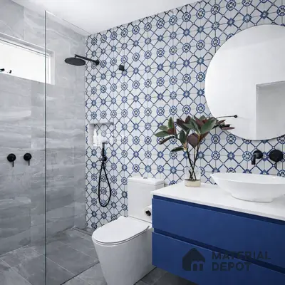 Modern bathroom with blue geometric patterned wall tiles, grey stone floor tiles, and blue laminate vanity
