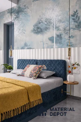 Scandinavian bedroom with blue suede upholstered bed, chinoiserie wallpaper, and fluted white wall panels