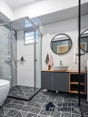 Modern bathroom with geometric black-and-white floor tiles, grey wall tiles, and matte black vanity