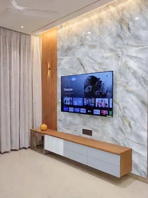 Modern TV unit with white marble laminate, walnut wood laminate, and gold accent wall in 3 BHK apartment Maithri Shilpitha Splendour Mahadevapura Bengaluru
