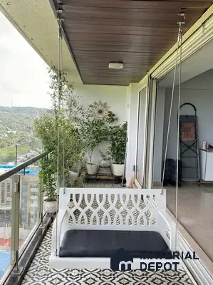 Modern balcony with patterned floor tiles, wooden ceiling panels, and white swing