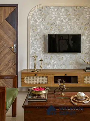 Traditional living room with floral wallpaper, natural wood TV unit, and cane panel details