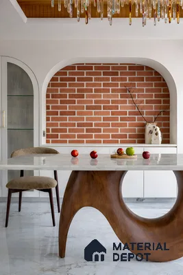 Mid-century modern dining room with marble tabletop, sculpted wood base, and brick wall tile accent