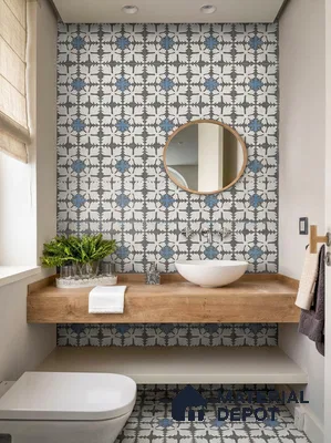 Modern bathroom with blue and white patterned tiles and natural wood countertop
