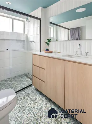 Modern bathroom with patterned blue and green floor tiles, white subway wall tiles, and light oak laminate vanity
