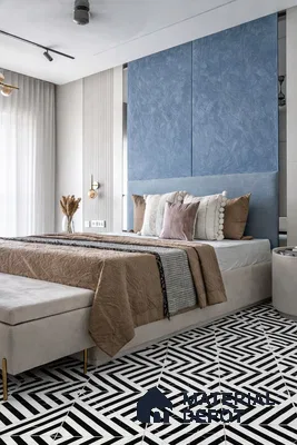 Modern bedroom with blue textured wall panels and black-and-white geometric floor tiles