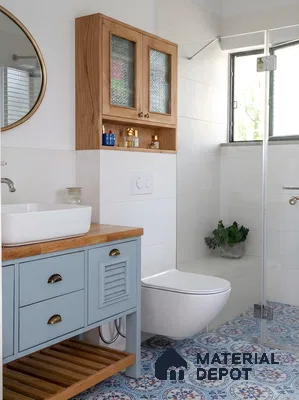 Scandinavian bathroom with blue patterned moroccan floor tiles, light wood vanity, and white wall tiles