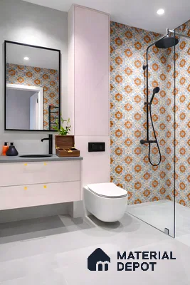 Modern bathroom with pastel pink vanity, grey countertop, and orange-blue patterned moroccan wall tiles