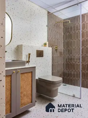 Modern bathroom with terrazzo wall and floor tiles, cane vanity, and brown geometric shower tiles