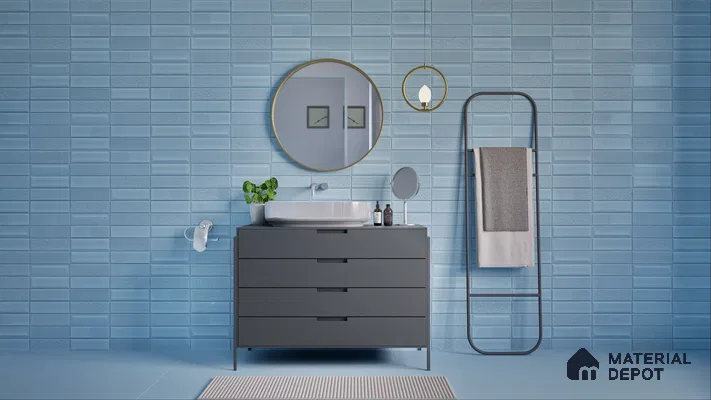 Sleek bathroom design featuring blue textured tiles, a dark grey vanity with a white basin, round mirror, and minimalist towel rack. | Material Depot