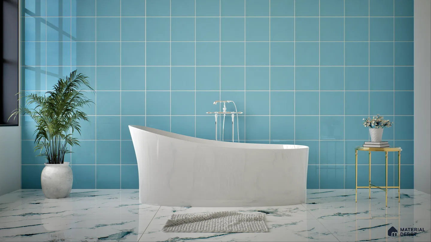 A serene blue bathroom featuring a freestanding white tub, blue tiled wall, marble floor, potted plant, and a small side table. | Material Depot