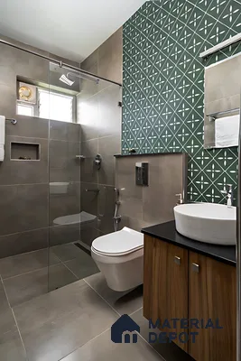Modern bathroom with green geometric patterned wall tile, taupe matte wall and floor tiles, and wood laminate vanity