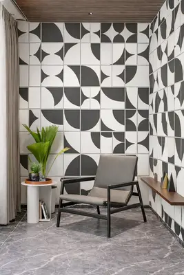 Modern living room with geometric black-and-white wall tiles and grey marble floor tile