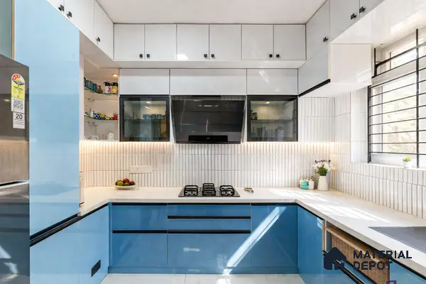 Modern dual tone kitchen with sky blue high gloss laminate, frosty white laminate, and white vertical kitkat backsplash tiles in 3 BHK apartment SLV Parkview Apartment Bengaluru
