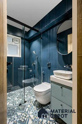 Modern bathroom with deep blue wall tiles and blue geometric patterned floor tiles of 3 BHK apartment in Sattva Celesta Salapuria in Bengaluru