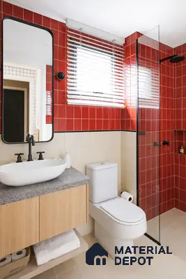 Modern bathroom with red wall tiles, beige floor tiles, and light wood vanity