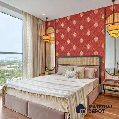 Traditional bedroom with red damask patterned wallpaper, cane headboard, and wooden flooring