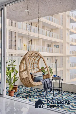 Bohemian balcony with rattan swing and blue geometric patterned floor tiles