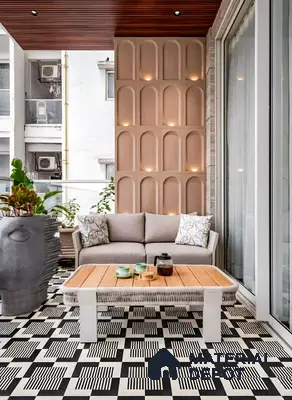 Modern balcony with black-and-white geometric floor tiles, wood slat ceiling, and beige arched wall panels in 3 BHK apartment Sterling Brookside Brookefield Bengaluru