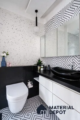 Modern bathroom with terrazzo wall tiles, geometric black-and-white floor tiles, and black countertop