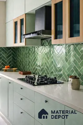 Modern kitchen with sage green laminate cabinets, white quartz countertop, and glossy green herringbone subway backsplash tile