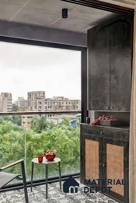 Modern balcony with black patterned floor tiles and cane-inset cabinet
