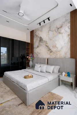 Modern bedroom with marble-look accent wall, grey upholstered bed, and glossy black wardrobe