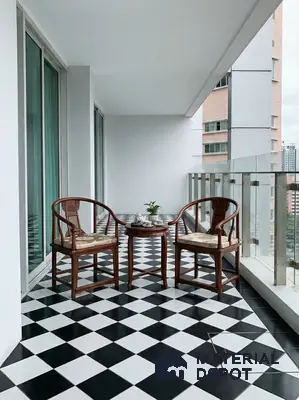 Modern balcony with black-and-white checkerboard floor tiles and wooden accent chairs