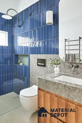Modern bathroom with blue geometric wall tiles, grey stone countertop, and wood vanity of 3 BHK apartment in Vaishnavi Gardenia Choodasandra Bengaluru