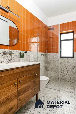 Mid-century modern bathroom with orange vertical subway wall tiles, terrazzo floor and wall tiles, and walnut wood vanity of 3 BHK apartment in Vaishnavi Gardenia Choodasandra Bengaluru