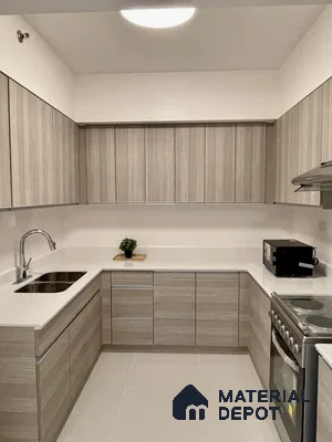Minimalist kitchen with light oak wood grain laminate cabinets and white quartz countertop in Bengaluru | Material Depot