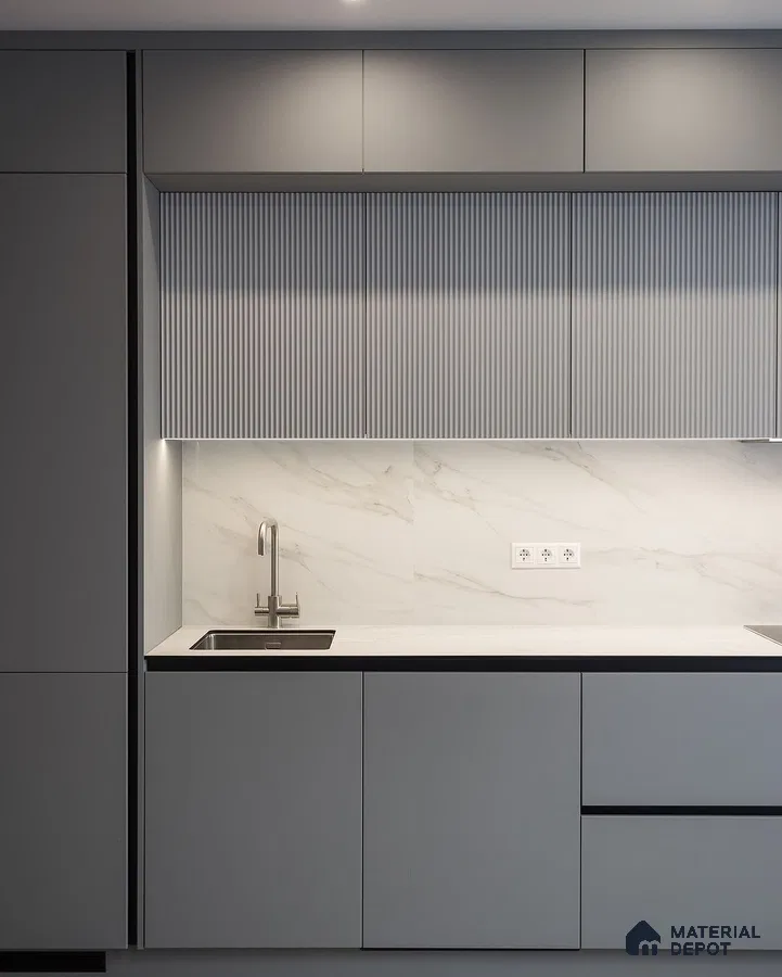 Minimalist kitchen with matte grey laminate, fluted upper cabinets, and white marble backsplash in Bengaluru | Material Depot