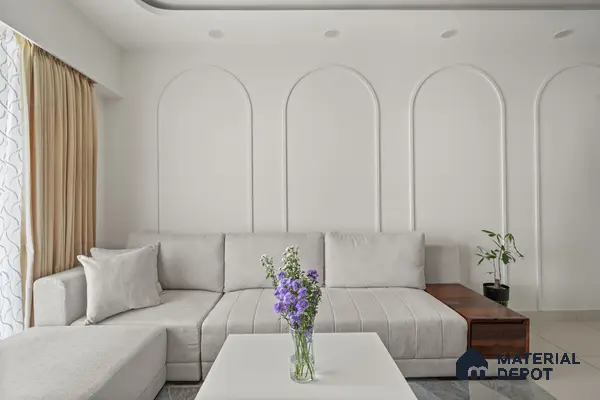 Minimalist living room with off white paint, light grey fabric sofa, and wooden accent side table of 2 BHK in Purva Palm Beach Hennur Bengaluru | Material Depot
