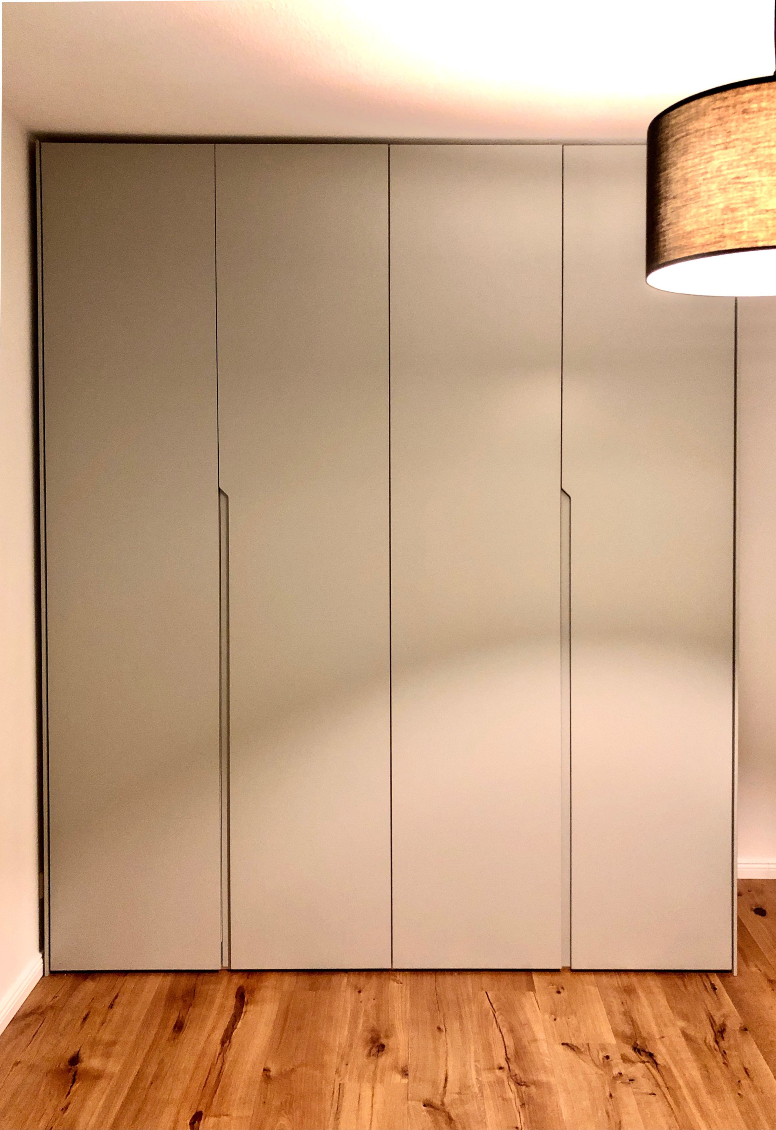 Minimalist wardrobe with matte light grey laminate shutters and natural oak wooden flooring | Material Depot